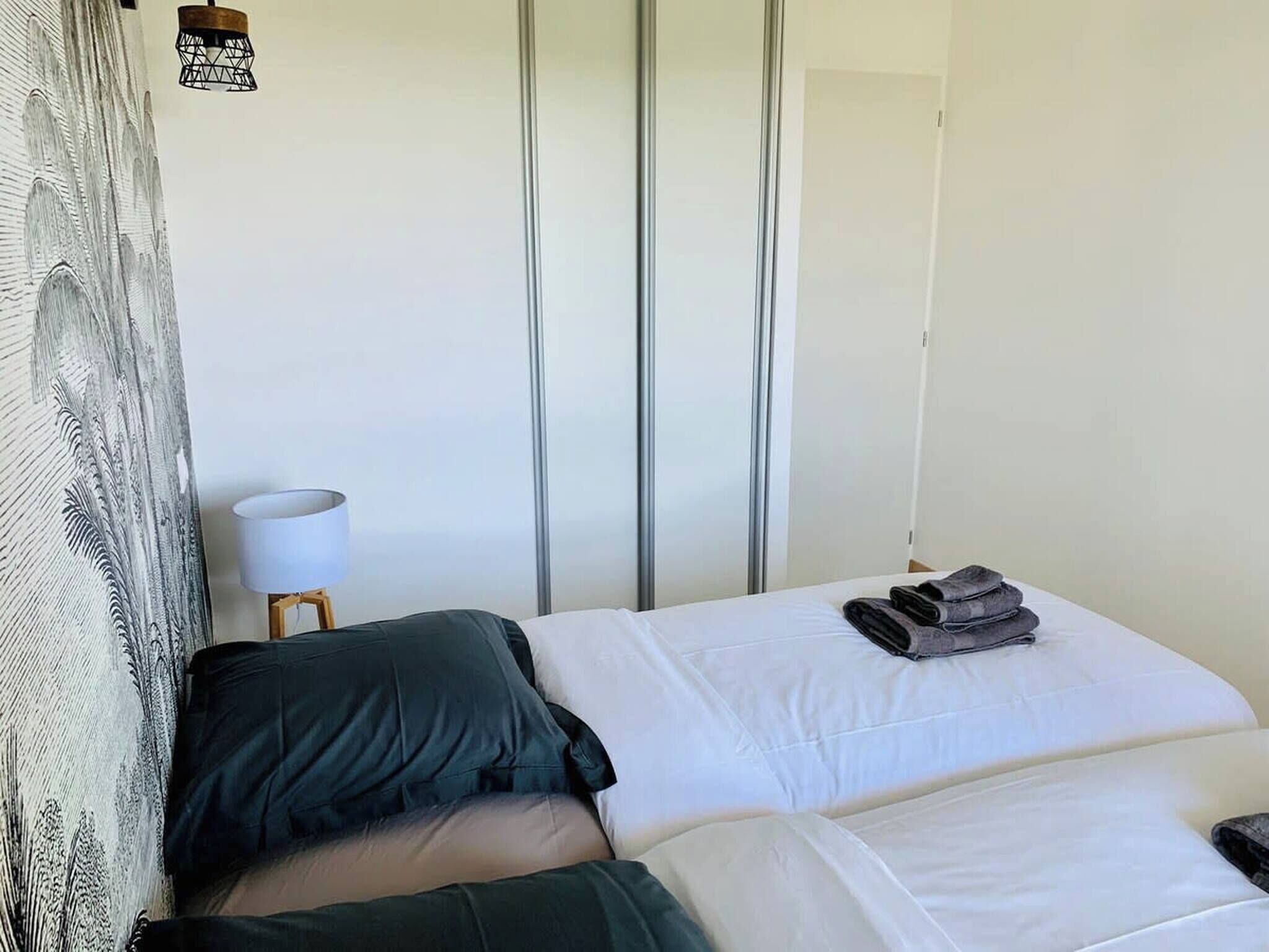 Una camera d'albergo con un letto, una lampada e una parete con persiane verticali.