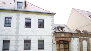 A building with a white facade, multiple windows, and a stone entrance.