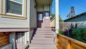A two-story house with a front porch, a wooden fence, and a clear blue sky. - Pet-friendly Condo < 2 Mi to Alameda Beach! (Alameda)