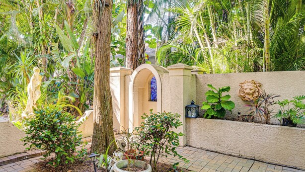 A garden with a stone wall, potted plants, and a small archway. - 3 Mi to 5th Ave South: Quiet Getaway w/ Garden (Naples)