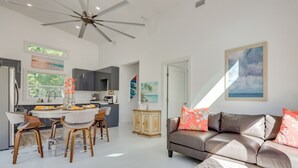 A modern kitchen with a dining area, a grey sofa, and a ceiling fan. - Fish, Boat & Unwind: Gem 6 Mi to Gulf Shores Beach (Gulf Shores)
