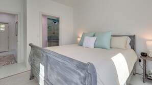 A bedroom with a bed, bedside table, and a door leading to another room. - Fish, Boat & Unwind: Gem 6 Mi to Gulf Shores Beach (Gulf Shores)