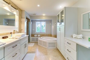 A modern bathroom with a large mirror, a bathtub, and a vanity with a sink. - Walk to Wabasso Beach: Home w/ Hot Tub & Bikes (Vero Beach)