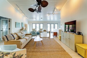A spacious living room with a sofa, armchairs, a coffee table, a television, and a dining area with a table and chairs. - Walk to Wabasso Beach: Home w/ Hot Tub & Bikes (Vero Beach)