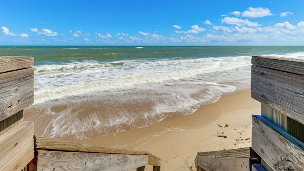 A wooden beach boardwalk leading to the ocean with waves crashing onto the shore. - Walk to Wabasso Beach: Home w/ Hot Tub & Bikes (Vero Beach)