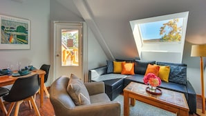 A cozy living room with a dining area, a sofa with colorful cushions, and a skylight. - Steps to Ski Lifts! Mountain Green Resort Retreat (Killington)