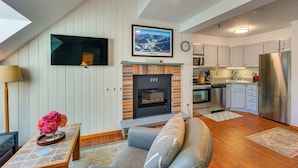 A modern living room with a fireplace, a flat-screen TV, and a sofa. - Steps to Ski Lifts! Mountain Green Resort Retreat (Killington)