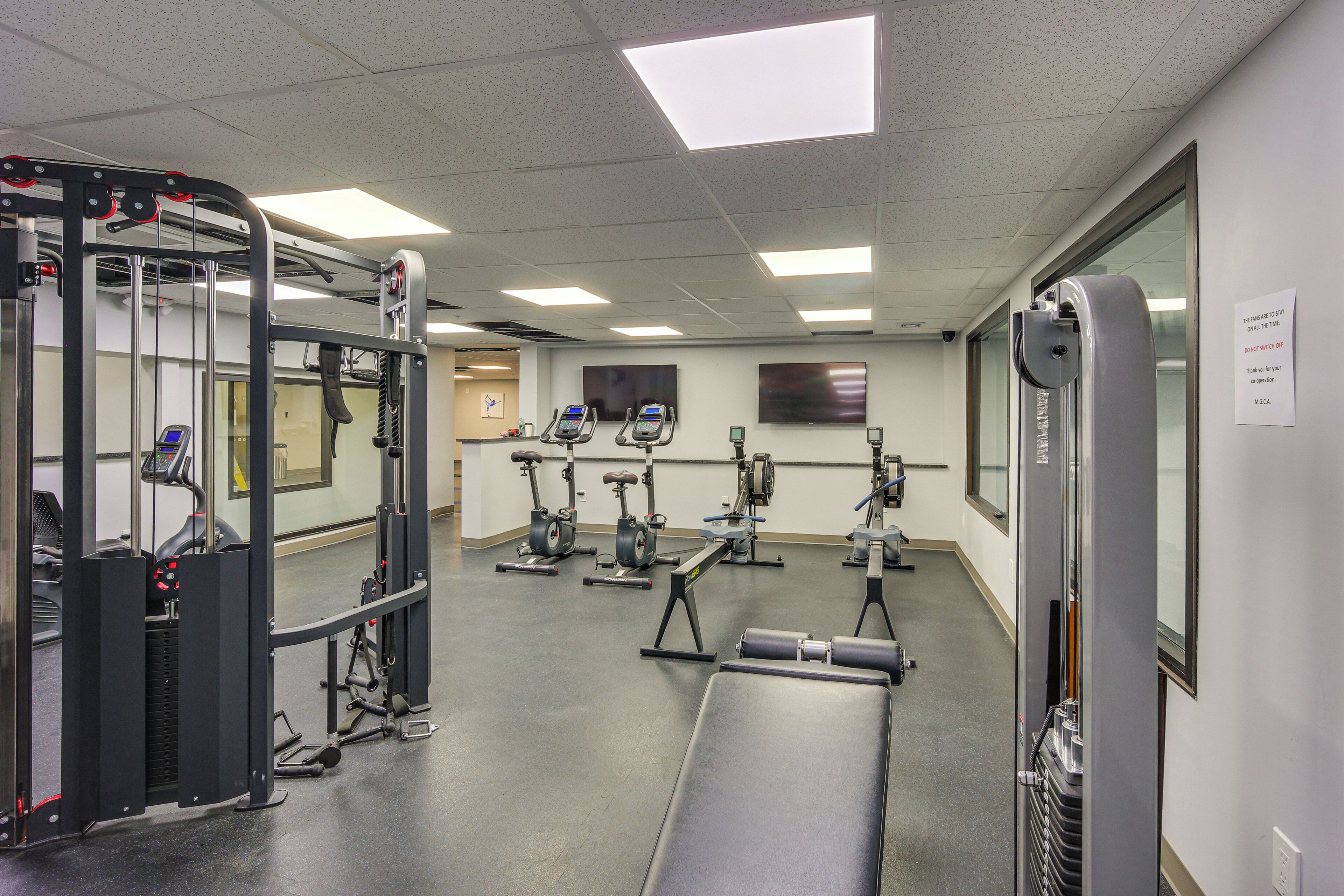 Et fitnesscenter med forskellig træningsudstyr, herunder løbebånd og styrkemaskiner.