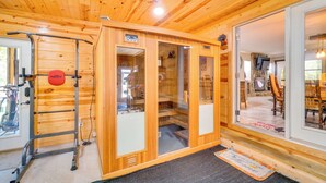 Eine Holzhütte mit Sauna, Fitnessgeräten und Essbereich.