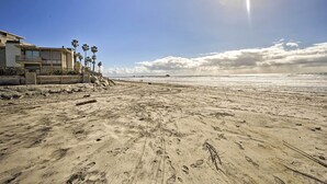 Ein Strand mit Fußabdrücken und einer Holzkonstruktion.