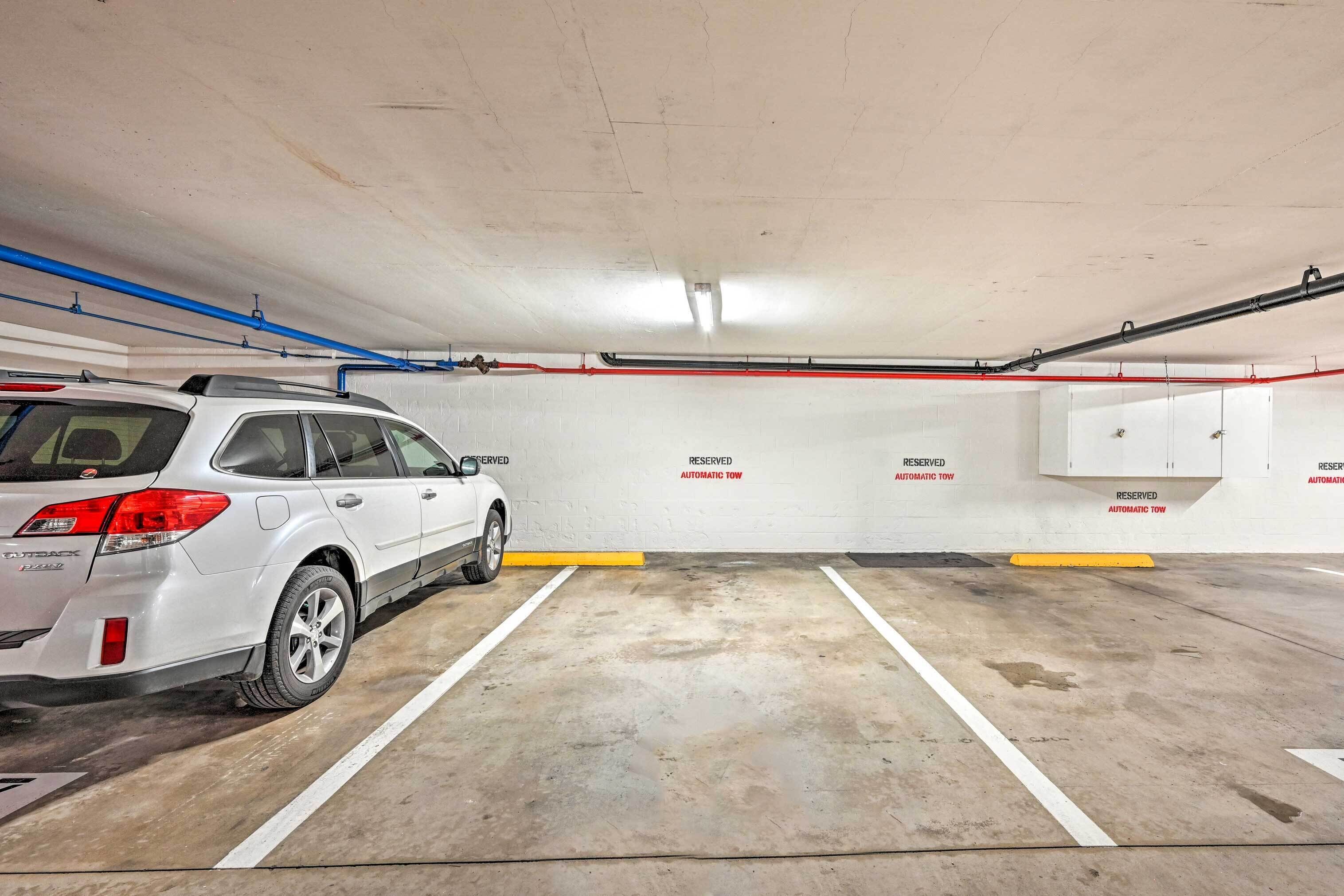 Un parking avec des murs blancs, des places de stationnement délimitées et un VUS blanc garé dans l’une d’elles.