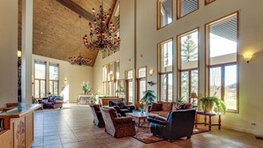 A spacious living area with a pool table, multiple seating arrangements, and large windows offering views of the outdoors. - Stunning San Juan Mtn Views: Cabin Near Skiing! (Durango)