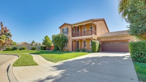 A two-story house with a front garage, a curved driveway, and well-maintained landscaping. - Outdoor Oasis w/ Fire Pit: Pet-friendly Fresno Gem (Fresno)
