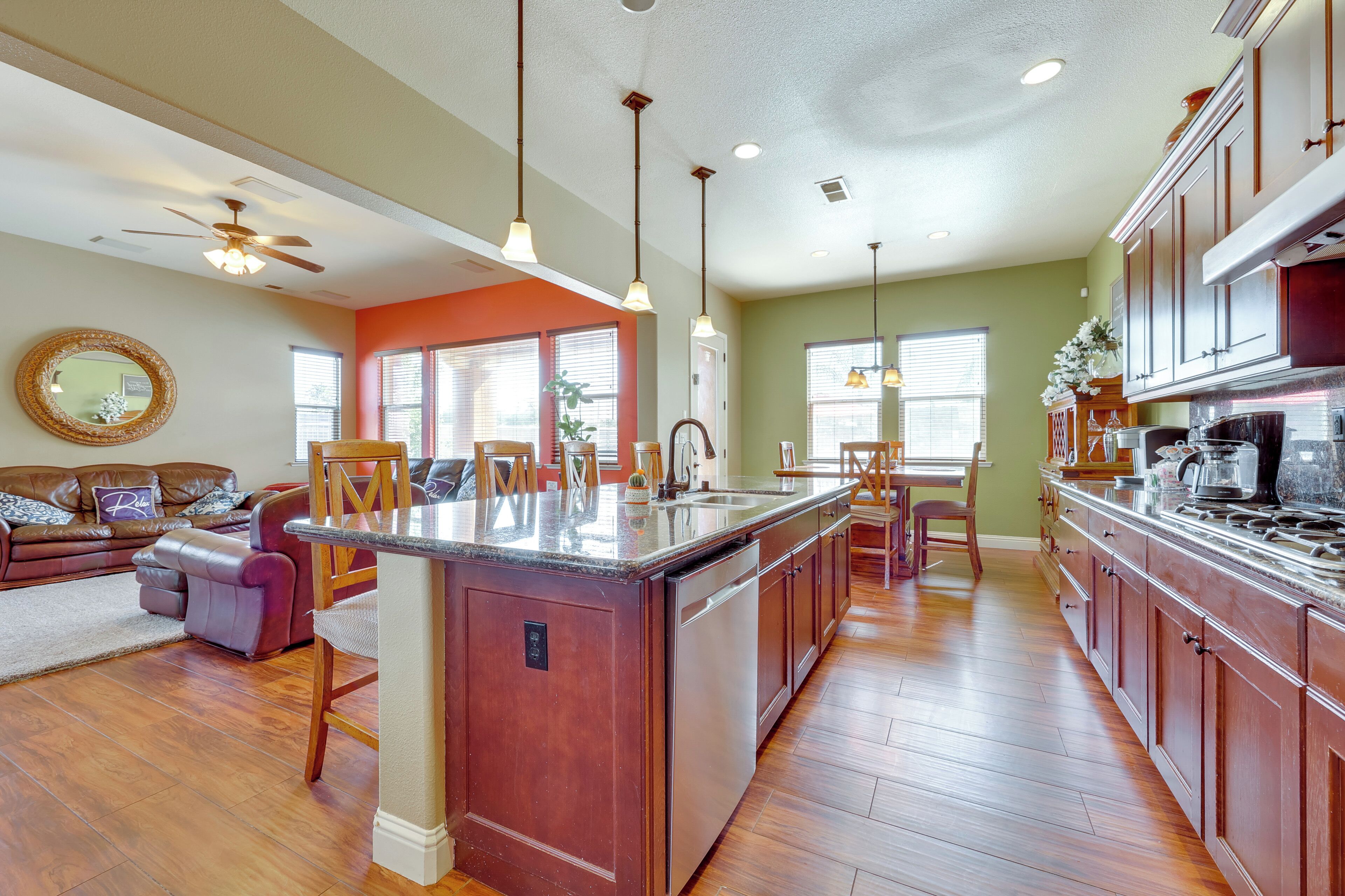 A spacious kitchen with a large island, wooden cabinets, and a dining area with a table and chairs.