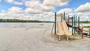Ein Spielplatz mit Rutsche und Treppe in der Nähe eines Sees.