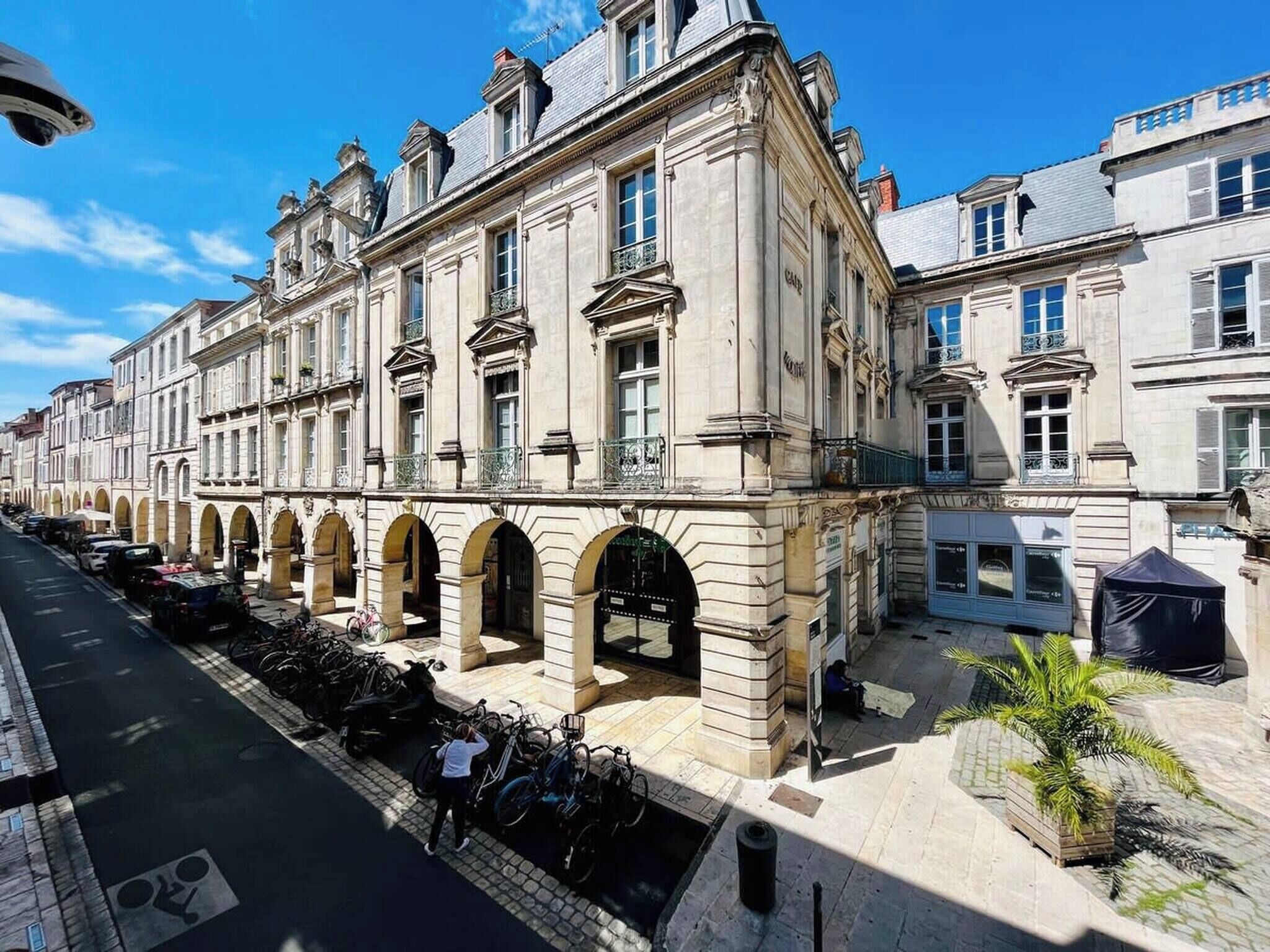 A historic building with classical architecture, featuring a central courtyard with arches and a covered seating area.