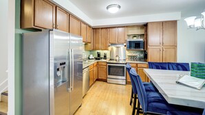 Una cucina moderna con mobili in legno, elettrodomestici in acciaio inossidabile e un piano di lavoro in marmo.