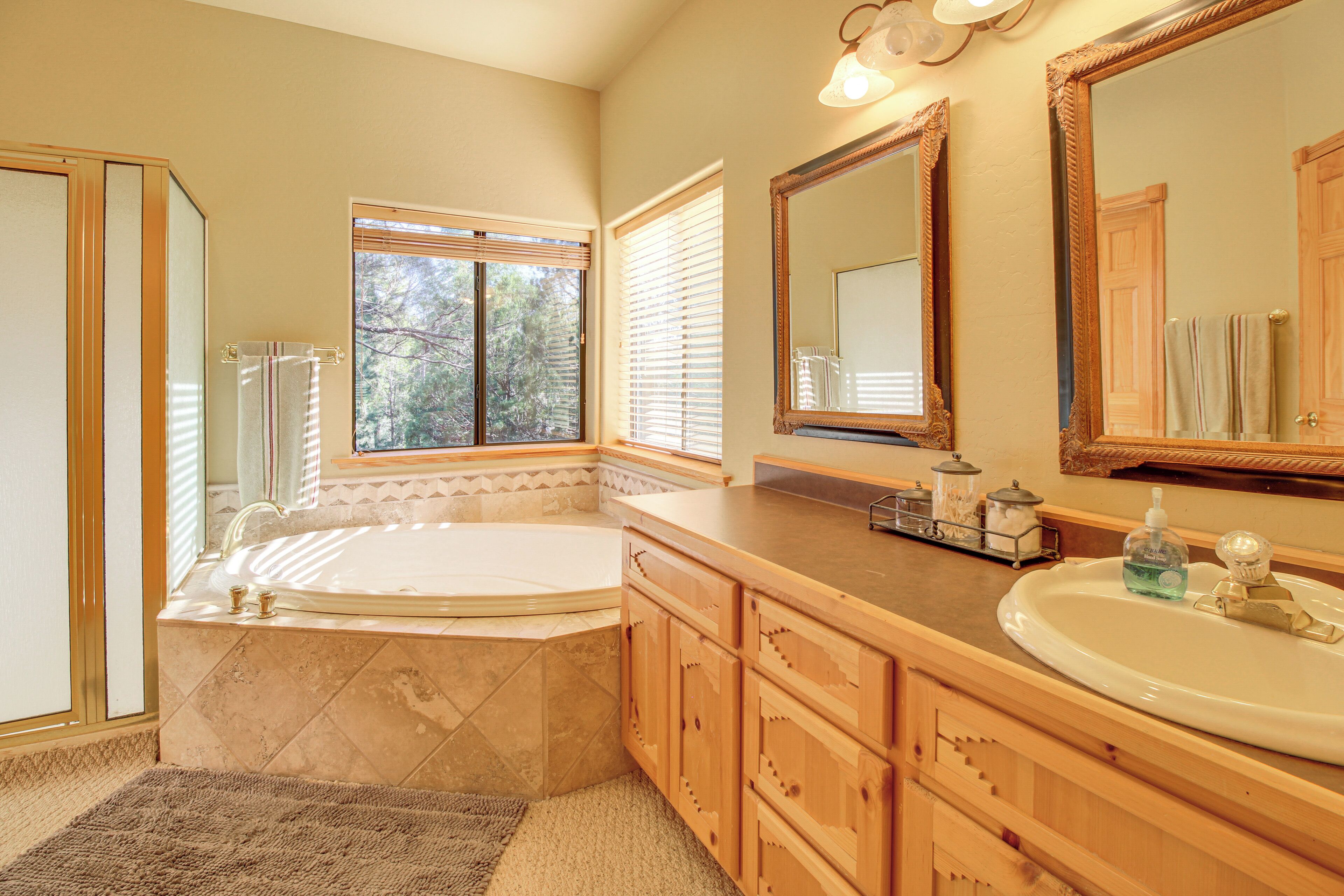 A bathroom with a bathtub, vanity, and large mirrors.