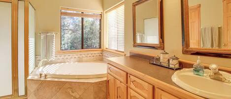 A bathroom with a bathtub, vanity, and large mirrors.