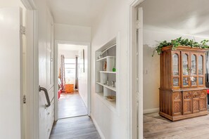 A hallway with a wooden cabinet and shelves, a door with a handle, and a wooden floor. - High Walkability! Extended Stay in Riverside (Riverside)