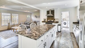 A spacious kitchen with a large island, built-in appliances, and a laundry area. - 8 Mi to Jiminy Peak Resort: Mtn-view Home w/ Deck (Stephentown)