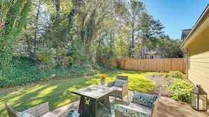 A patio area with outdoor furniture, a table, and a lantern. - 2 Mi to Ksu: Family Home w/ Games, Near Parks (Kennesaw)