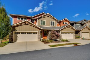 A multi-story residential building with a garage, a stone facade, and a well-maintained lawn. - Hike, Dine & Explore Asheville: Black Mtn Getaway! (Black Mountain)