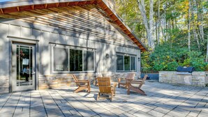 A modern house with a patio area featuring outdoor furniture and a grill.