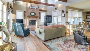 A spacious living room with a fireplace, a large window, and a dining area.