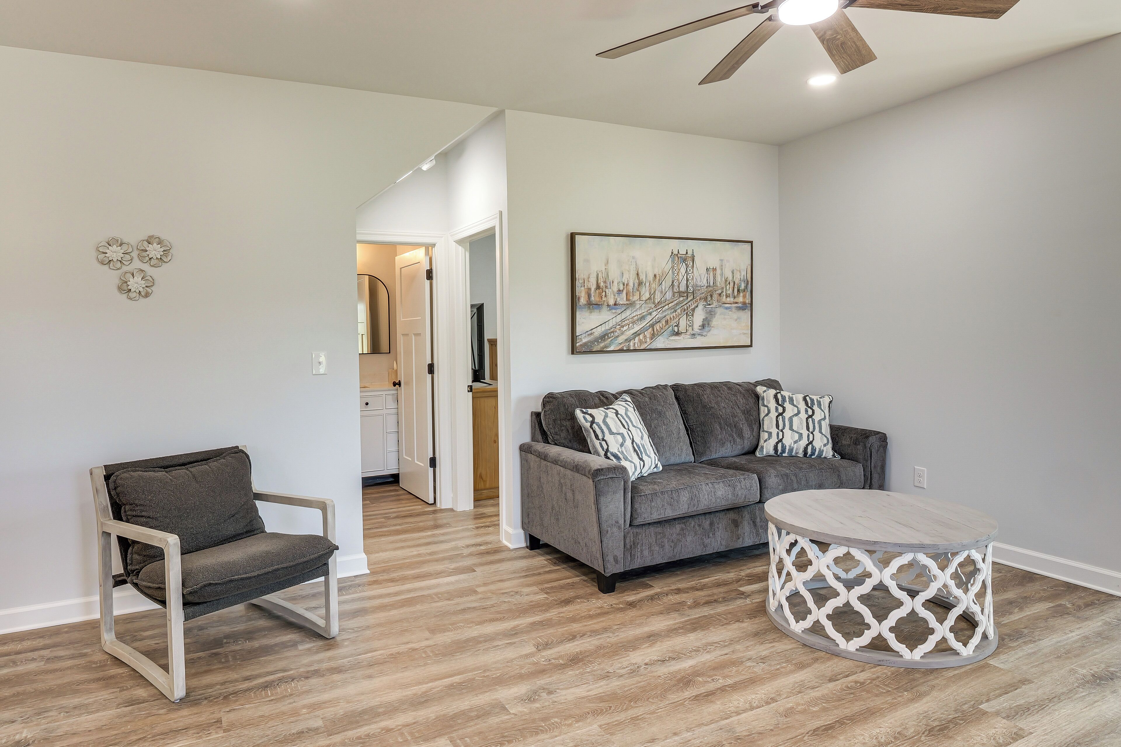A modern living room with a grey sofa, a round coffee table, and a chair.
