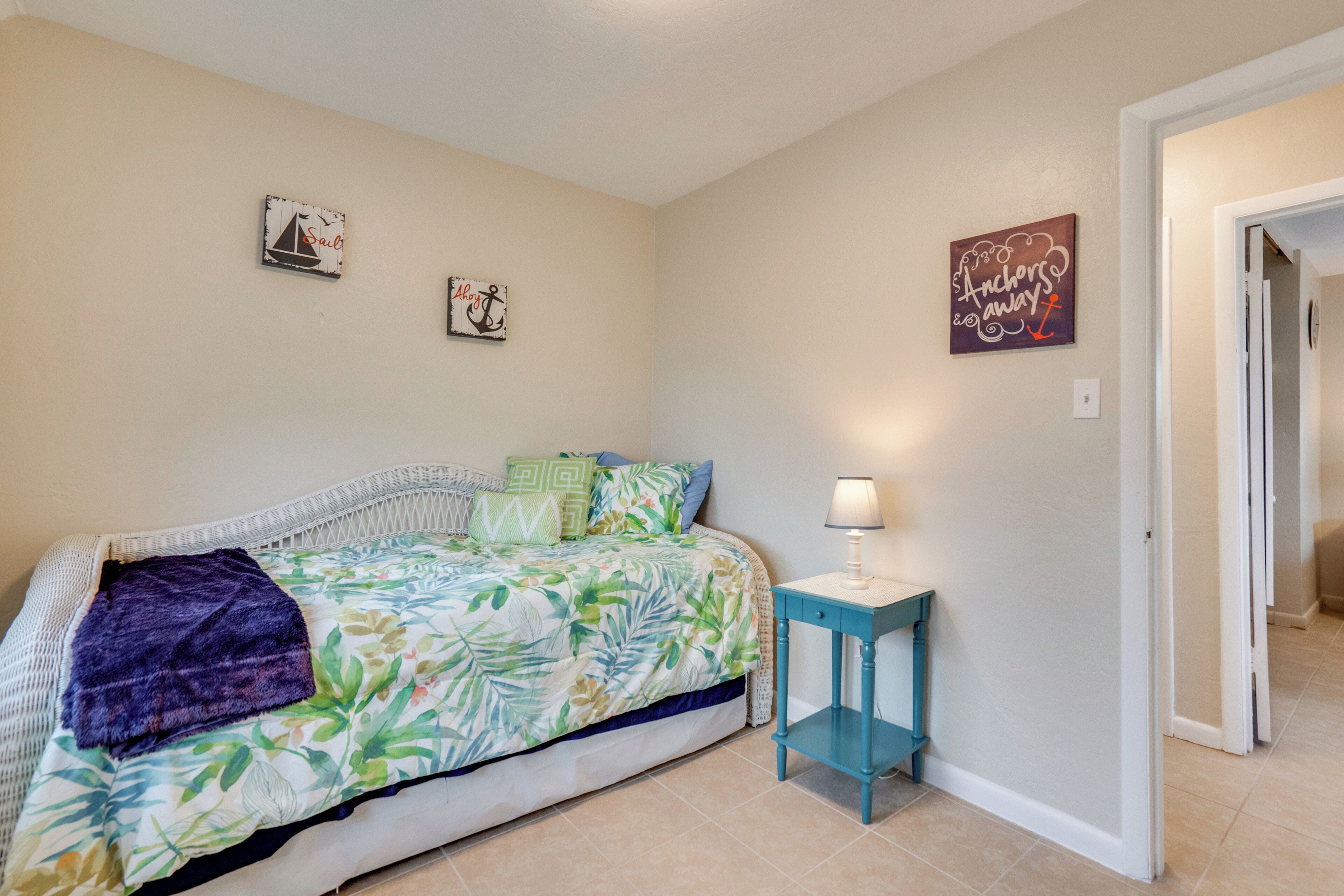 A bedroom with a bed, a nightstand, and wall art.