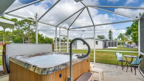 A hot tub under a covered patio with a view of a house and trees. - Relax in Hot Tub, Walk to Springs: North Port Home (North Port)