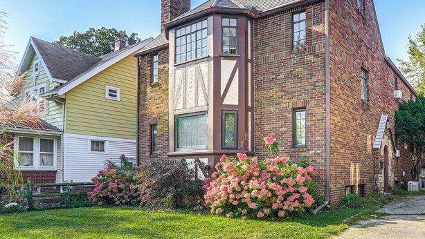A two-story house with a prominent corner bay window and a brick facade. - Striking Tudor Revival in Five Points District! (Toledo)