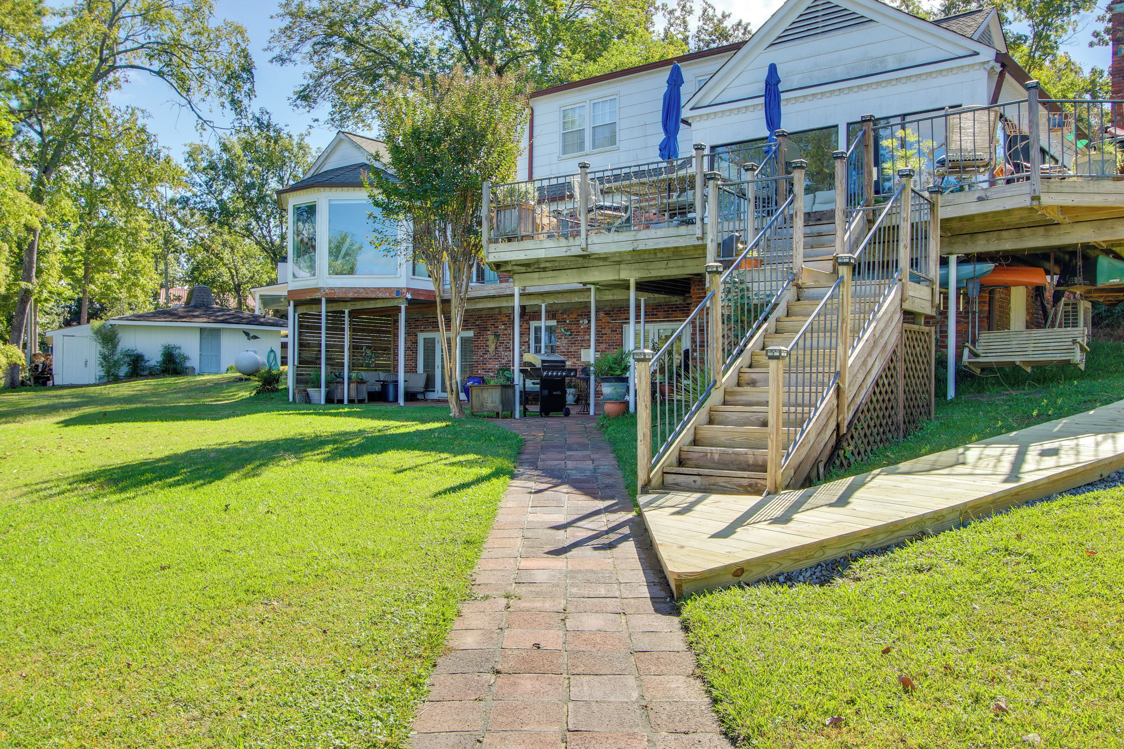 A two-story house with a covered porch, a staircase, and a brick pathway leading to the entrance.