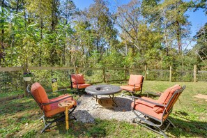 A circular outdoor seating area with four orange chairs and a central fire pit. - Explore Historic North Georgia! Group-ready Escape (Murrayville)