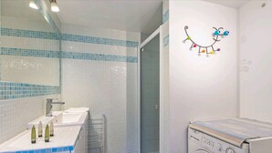 A bathroom with a sink, mirror, and a wall-mounted light fixture.