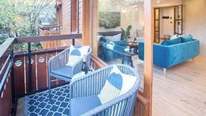 A modern outdoor seating area with wicker furniture and a blue sofa inside a well-lit room. - More Mountain  - Demi Lune. Central Morzine location and less than 2 minutes walk to main ski lifts, bars and restaurants. (Morzine)