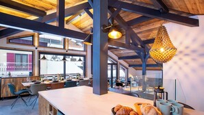 Una cocina amplia con una isla grande, vigas de madera y vistas al exterior.