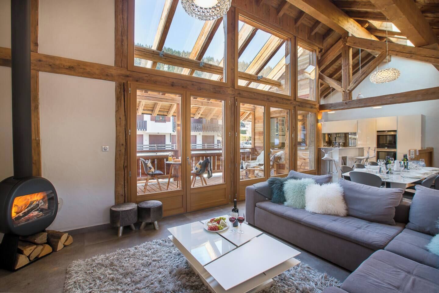 Un salon chaleureux avec une cheminée, un canapé et un coin repas avec une table mise pour deux personnes.