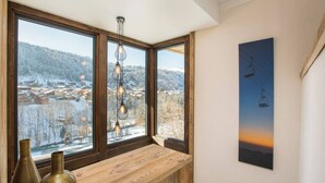 A room with large windows, a wooden bench, and a hanging light fixture. - More Mountain - Chalet La Godille. Luxury Chalet with large Terrace and Outdoor Jacuzzi split over 3 levels next to the Super Morzine Telecabine. (Morzine)