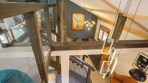 A modern interior with a wooden staircase, a cozy seating area, and a ceiling with exposed beams. - Apartment Grand Central hosted by More Mountain, Morzine | Luxury 3 Bed 3 Bath | Sleeps 6. Luxurious and Spacious duplex Penthouse apartment in the centre of Morzine, only 2 minutes walk on the flat to both the Pleney and Super Morzine Telecabines. (Morzine)