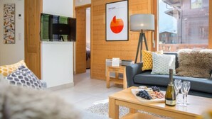 Een moderne woonkamer met een bank, salontafel en een eethoek, compleet met eten en wijn.
