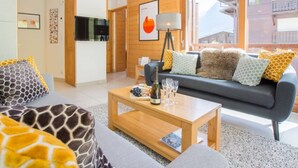 Een moderne woonkamer met een bank, salontafel en een televisie.