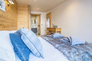 Une chambre à coucher avec une tête de lit en bois, un lit recouvert de fourrure et un bureau en bois avec une chaise.