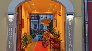 A hotel entrance with a red carpet, a sign reading "PROMENADE HOTEL," and a staircase leading to the upper floor. - Hotel Promenade (Shkodër)