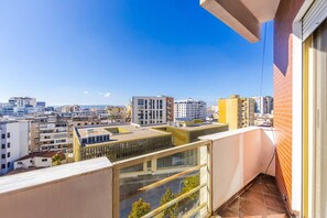 Un edificio de gran altura con vistas a un paisaje urbano, que incluye varios edificios y un cielo despejado.