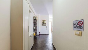 A hallway with a 'No Smoking' sign, a fire extinguisher, and a door leading to another room. - Spacious Stay in the Heart of Tirana 2BR City View (Tirana)