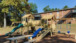Un parque infantil con toboganes y mesas de picnic.