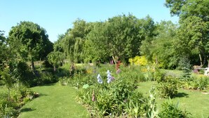A well-maintained garden with various plants and trees. - Apartment 'Villa Am Alten Deich' with Shared Terrace, Shared Garden and Wi-Fi (Butjadingen)