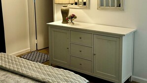 Une chambre à coucher avec un lit, une commode, un miroir et un ventilateur de plafond.